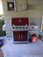 Front view of closed barbecue showing body, control knobs and cabinet