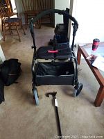 Walker fully assembled with seat, storage bag, and cane in foreground