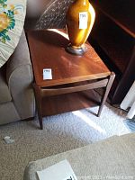 Front-left angle view showing rectangular top with wood grain and single lower shelf