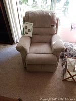 Front view of beige lift chair with manual on seat