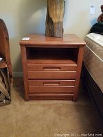 Front view of the solid wood nightstand showing two drawers and open shelf.