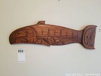 Full view of the entire carved salmon panel mounted on wall.