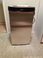 Frontal view of closed Danby mini fridge with stainless steel door and black top.