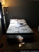 Full view of mattress and box spring on metal frame in bedroom
