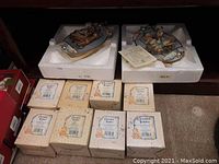 Two Bradford Exchange collectible bear figurines displayed on individual white bases with foam protective padding, along with eight Cherished Teddies figurines in original boxes arranged on the floor.