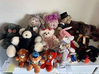 Overview photo of 18 teddy bears and a pink bunny with various outfits and colors on display.