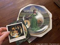 Scarlett O'Hara plate in green dress with accompanying Certificate of Authenticity held in hand