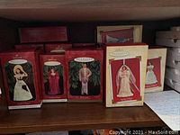Fifteen Hallmark Keepsake collector's ornaments in boxes, showing several red and cream packaging and figurines meant to represent Gone With The Wind characters.