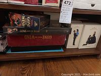 Two boxed sets of Gone With The Wind DVDs and two Hallmark Keepsake ornaments in boxes on a lower shelf.