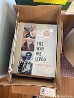 Open box view showing Reader's Digest's "The Way We Lived" large hardcover book and other books stacked inside a cardboard box.