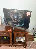 39 inch Vizio flatscreen TV powered on and displaying a dinosaur image, sitting on a wooden cabinet.