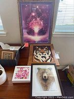 Four wall art pieces displayed together including parquetry tiger lion, bear portrait, floral painting, and spiritual art piece.