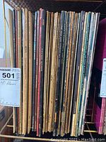 Photo of 40 vinyl LP records aligned vertically, showing the spines with artist and album titles.