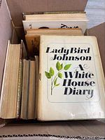Box of assorted vintage and antique books featuring the cover of 'A White House Diary' by Lady Bird Johnson