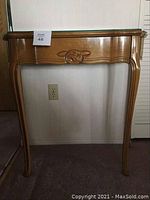 Front view of wooden entranceway table with decorative drawer and glass top.