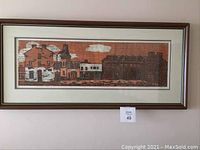 Overall view of framed woodcut print depicting brick fire station buildings under clouds