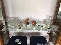 Full assortment view with taller and shorter crystalware, bowls, and candleholders on glass shelf