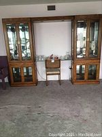 Full view of three piece Stanley furniture display cabinet set with chair in front.