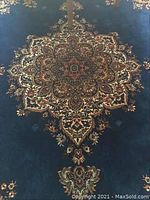 Close-up of central region showing beige and red medallion on navy blue field