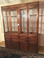 Front view of complete buffet and hutch showing four glass-panel doors and lower drawers