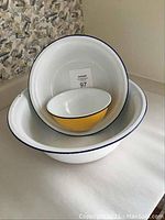 Three metal basins and bowls stacked, showing sizes and colors