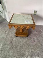 Square marble top pedestal end table shown from front with decorative scalloped apron edges and wooden bead trim.