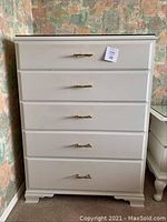 Front view of white painted high boy dresser with five drawers and brass handles