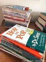 Stack of children's books featuring Dr. Seuss titles including 'Hop on Pop' showing cover and spine condition.