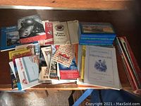 Photo of assorted train maps, brochures, and timetables spread on table including Cape Cod, New York Subways, Denver Rio Grande Waterproof Railroad, and more.