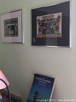 Two framed Maxfield Parrish prints hanging on wall above a coffee table book titled 'Maxfield Parrish Poster Book'.