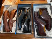 Three pairs of men's dress shoes: brown loafers, black oxfords, and burgundy oxfords shown in their boxes.
