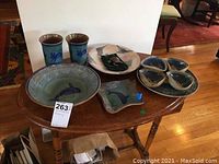 Wide view of all ceramics and carved turtle arranged on a wood table
