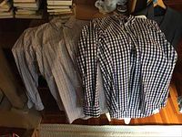 Five men's long sleeve checked pattern shirts hanging on a rack, showing varying designs and colors indicating Lands End brand.