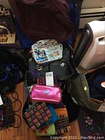 Multiple ladies hand bags in various styles and colors including felted wool and Bagalini brand bags with tags