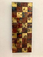 Full view of the rectangular wood panel art piece with multi-colored squares arranged in a grid pattern.