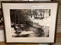 Full frontal photo of the framed limited edition black and white print depicting a snowy stream and forest scene, showing the overall artwork and frame.