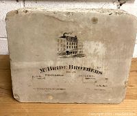 Full view of the rectangular lithographic printing stone showing the McBride Brothers image and text.