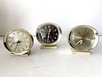 Front view of all three vintage Westclox clocks lined up side by side showing dial faces and metal frames.