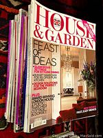 Stack of multiple House & Garden magazines showing the cover of one issue with interior dining room and floral décor