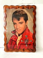 Full front view of the Elvis Presley clock showing the scalloped wood frame, large photo of Presley, and clock face elements.