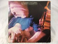 Front cover of the Harry Chapin Greatest Stories Live vinyl LP showing blurred image of Chapin with guitar.