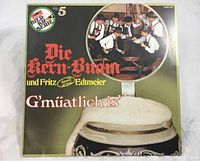 Front cover of Die Kern-Buam G'müatlich is' vinyl LP album showing men in traditional Bavarian clothing and a beer stein prominently displayed.