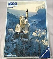 Box front displaying image of Neuschwanstein Castle in snow with 1500 pieces text and Ravensburger logo