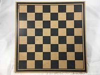 Photo of the wooden chessboard showing an 8x8 square pattern with natural wood and black squares and a double border.