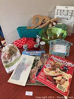 Complete overview of the 22-piece craft lot including books, frames, molds, jars, and vintage Coca Cola iron transfer.