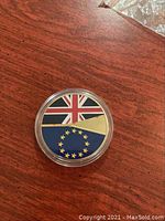 Photo of Brexit collector coin in capsule showing combined Union Jack and European Union flags design.