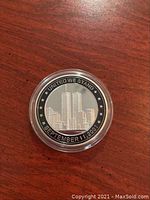 Front side of coin showing Twin Towers with inscription 'UNITED WE STAND SEPTEMBER 11, 2001' and stars around the edge.