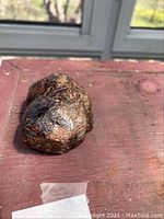 Front view of raw garnet specimen showing cluster of natural crystal faces on reddish surface