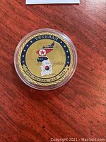 Close up photo of gold plated Korean War Veteran coin showing the design of the Korean Peninsula with North and South Korea flags and veteran text in capsule.