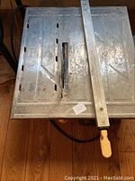 Top view showing the metal working surface and adjustable guide rail with a handle.